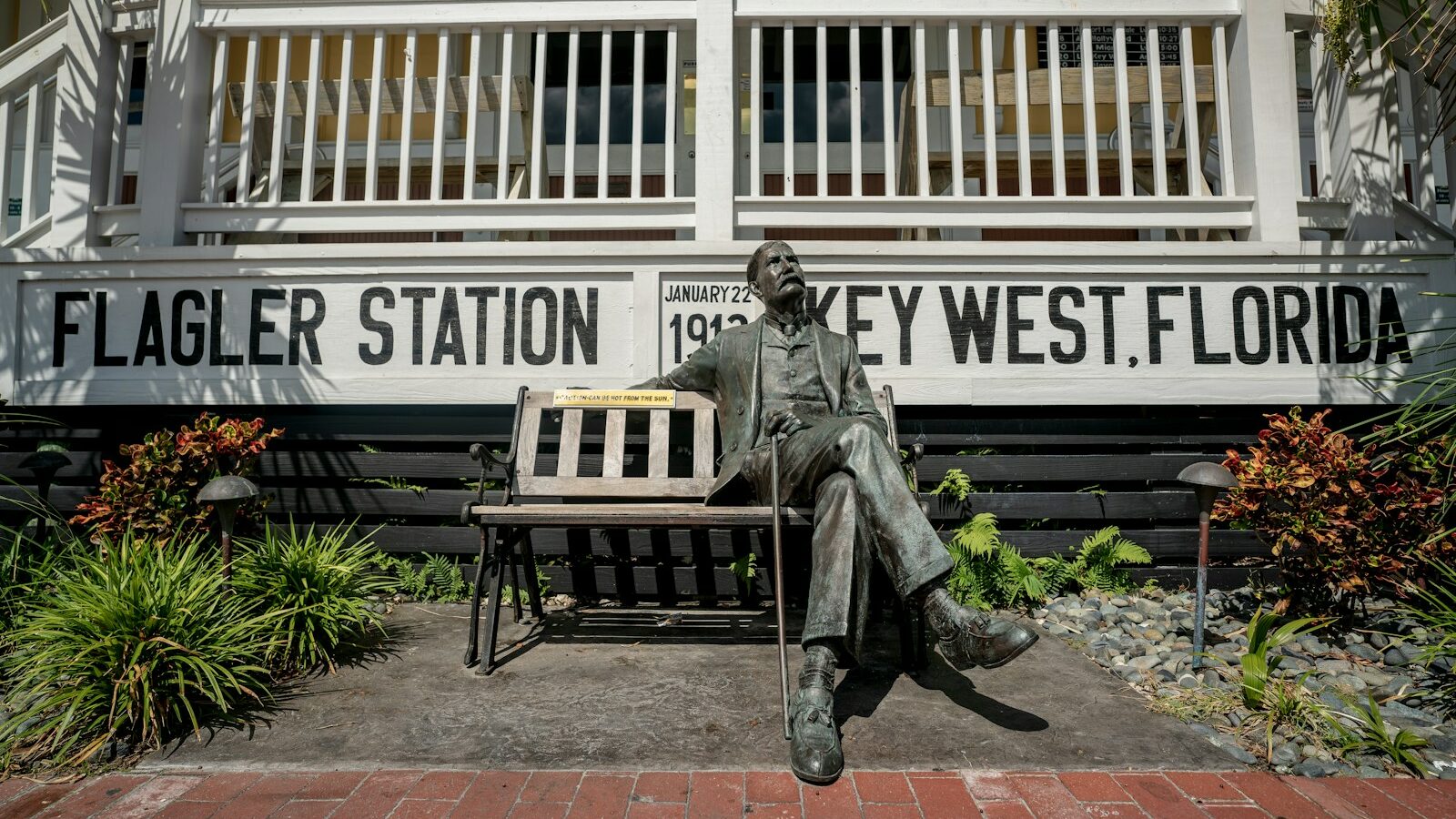 man sitting on bench statue