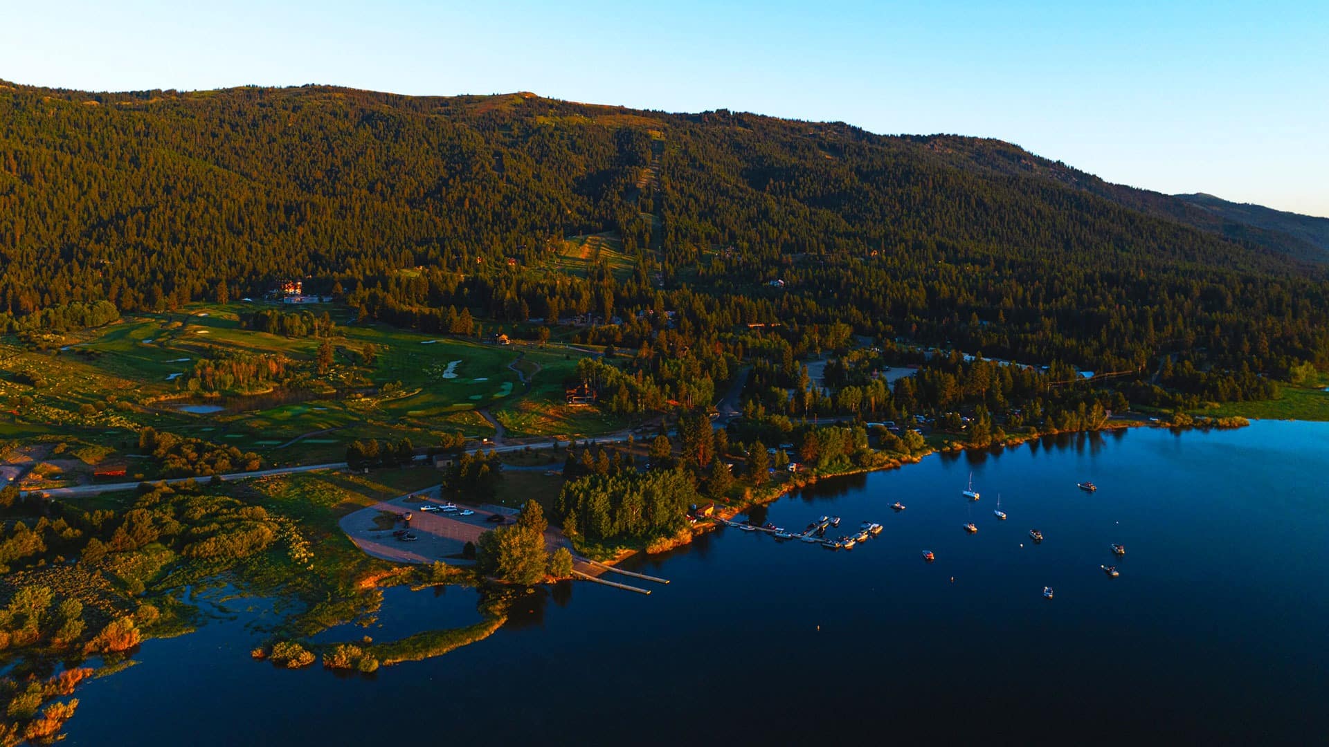Resort nestled between rolling hills and forest and lake side setting.