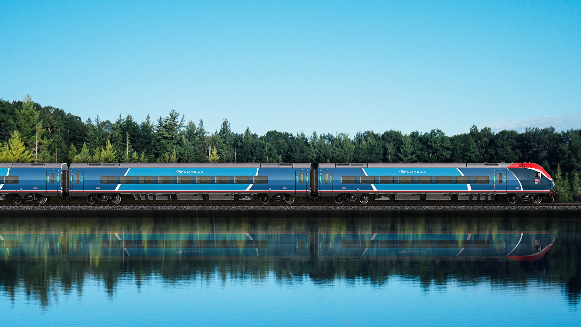Two-toned blue Amtrak train passing through a forest alongside a lake.