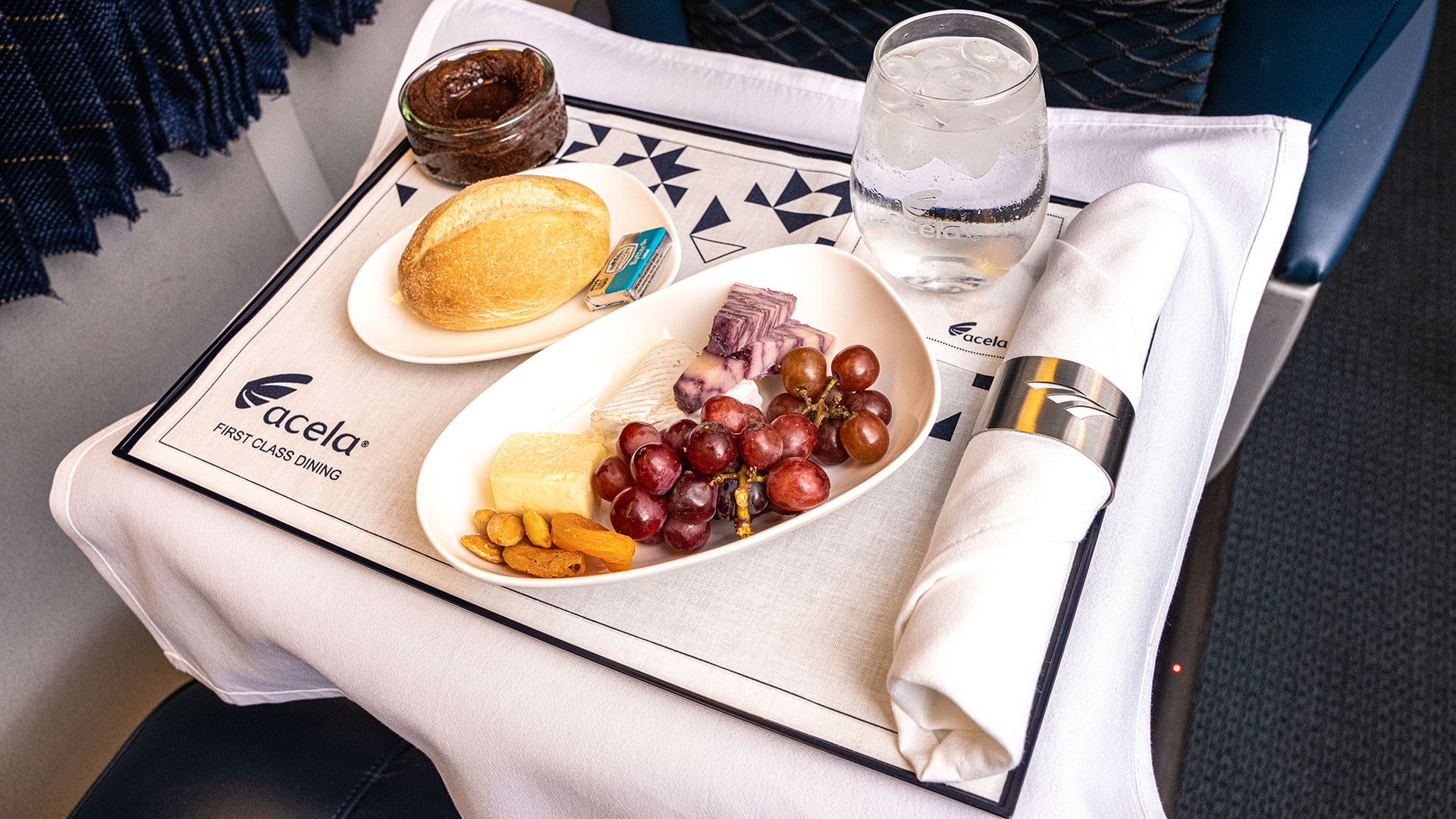 First Class place setting on board Amtrak with fruits in designer dishwear.