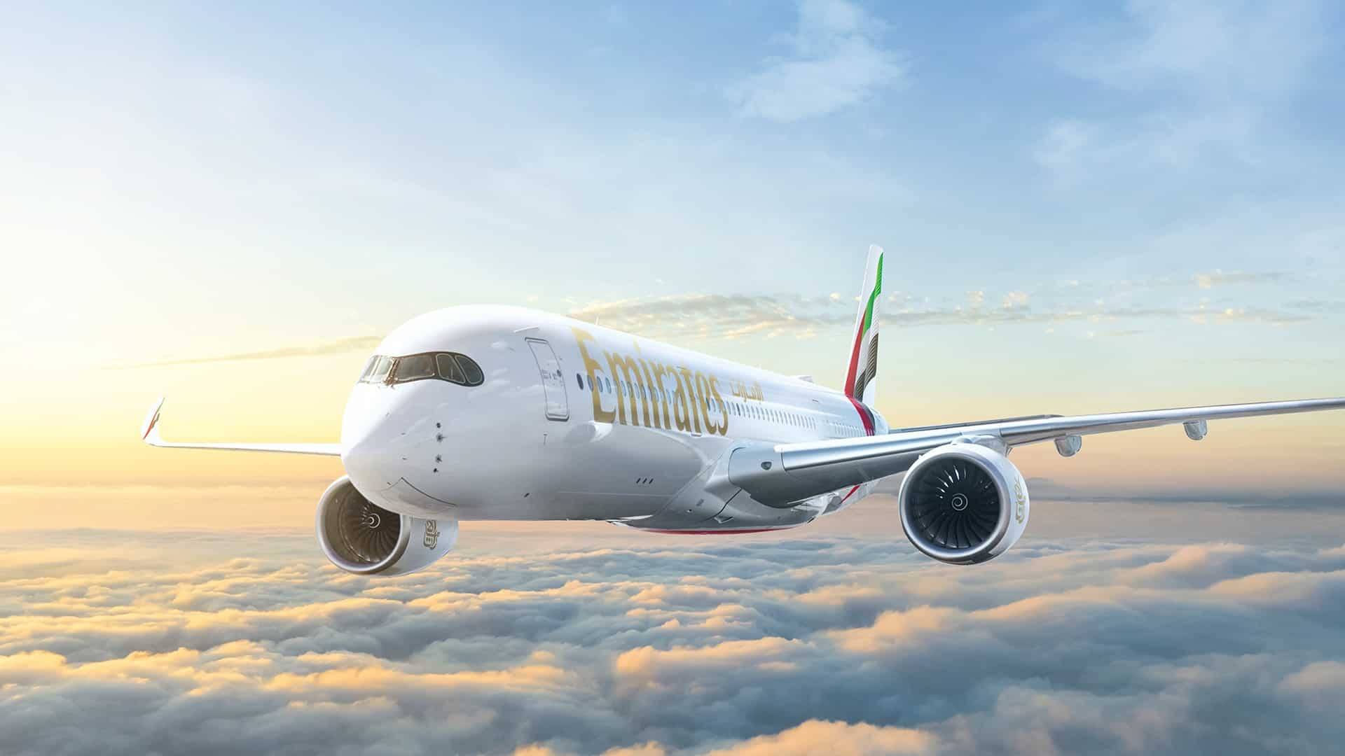 White Emirates plane flying during the sunset.