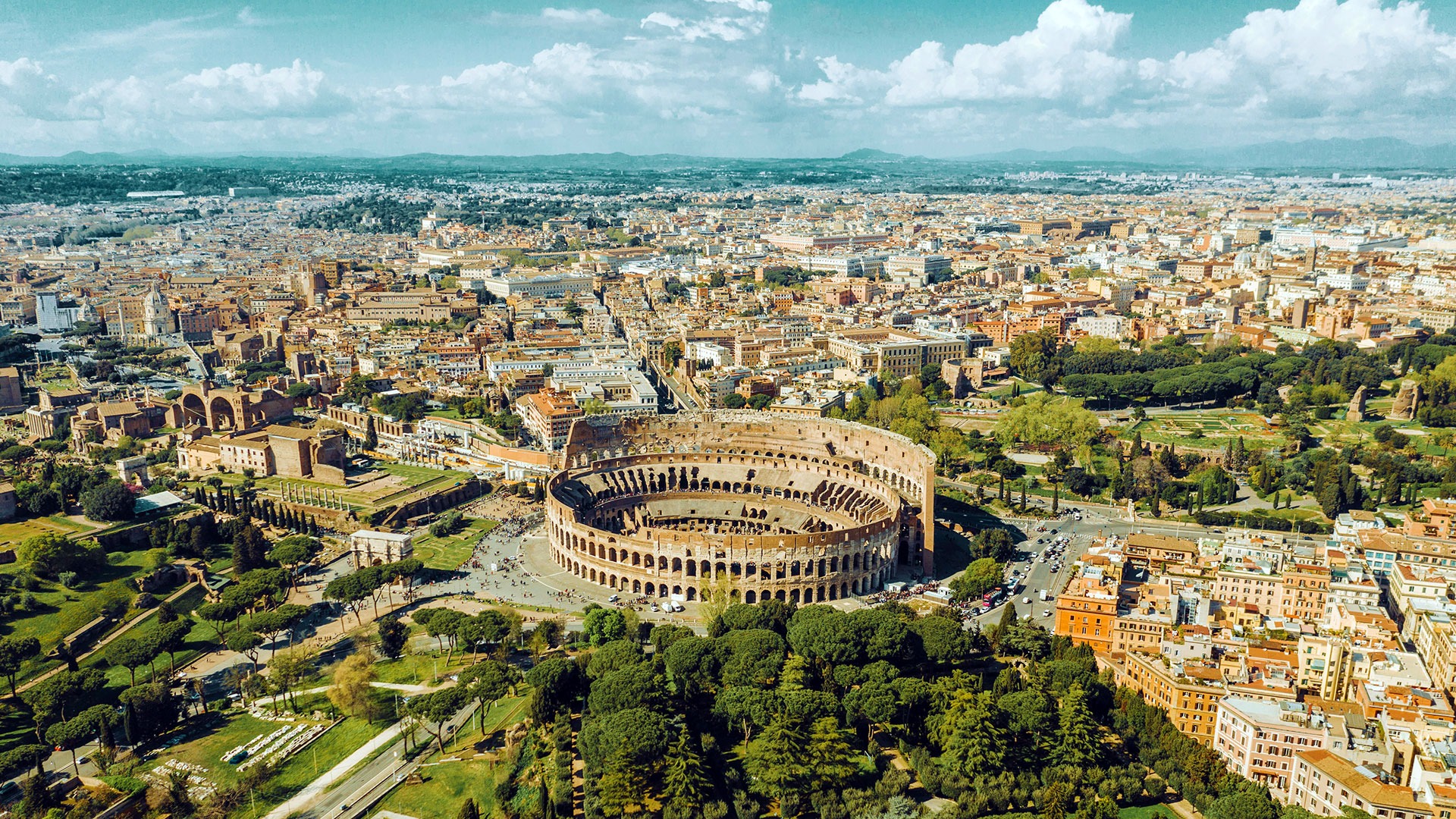 A city view of Rome with the Coliseum in the foreground.
