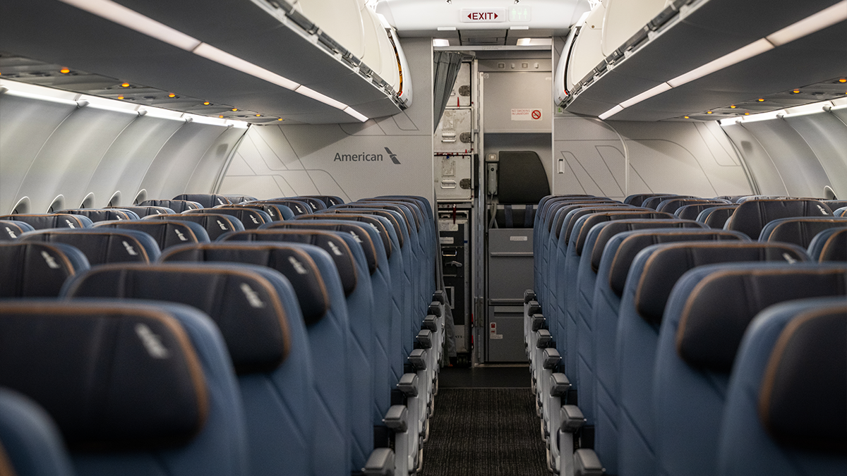 New interior of an American Airlines Airbus plane featuring various blue accents on the seats and carpet.
