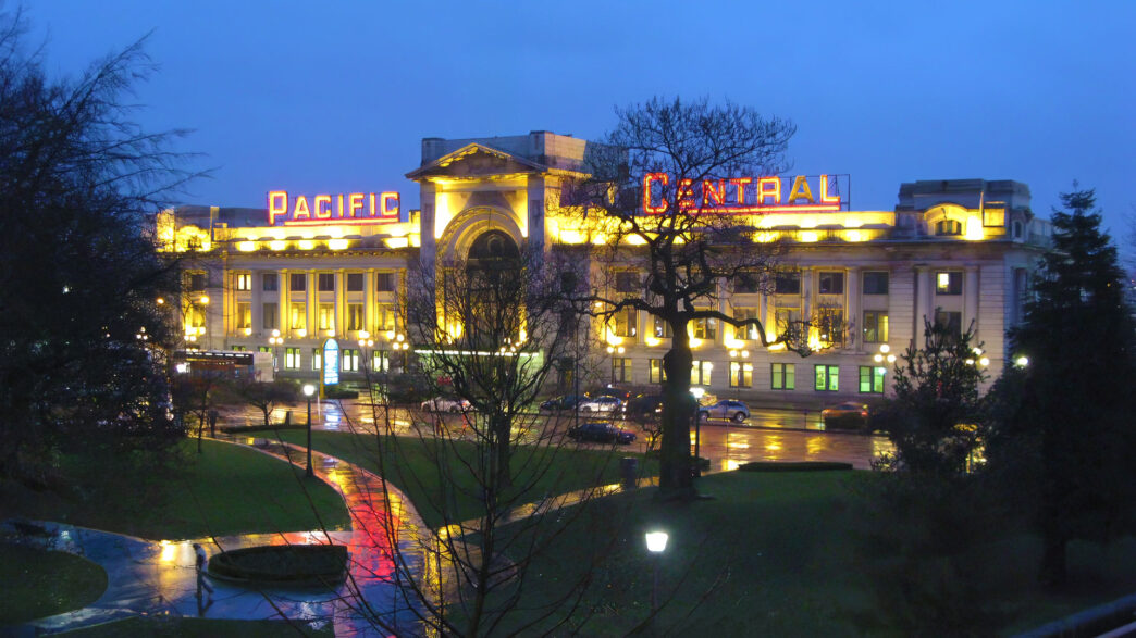 Pacific Central Station in Vancouver, BC on a rainy night with shiny sidewalks and streets.